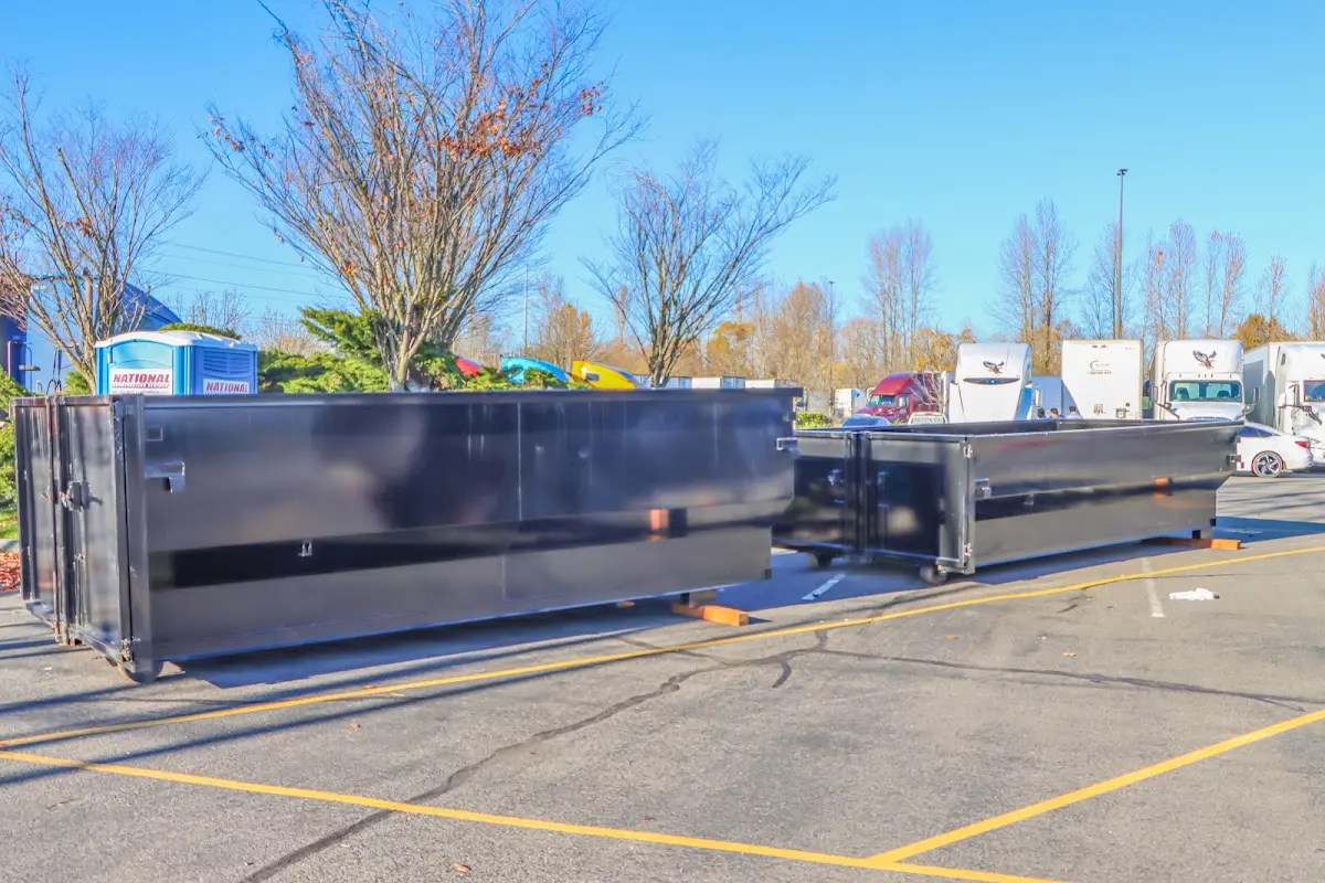 Professional dumpster rental service with roll-off container on residential driveway in Fairport